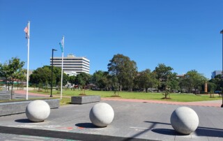 A photo of a community recreation area with a park and buildings in the background