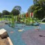 A photo of an outdoor play equipment area within a larger park