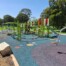 A photo of an outdoor play equipment area within a larger park