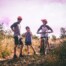A photo of a man and two children on bikes on a trail