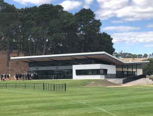 An image of a new, modern building next to a sports oval
